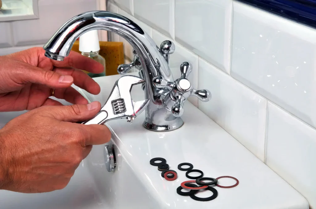 Plumber performing maintenance on a bathroom faucet in Johnstown