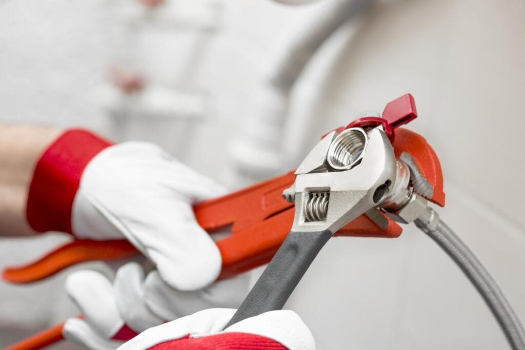Plumber holding pipe wrenches for an emergency repair in Johnstown