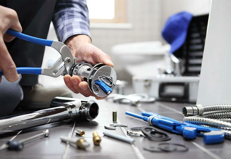 Technician repairing a plumbing fixture with professional tools in Johnstown