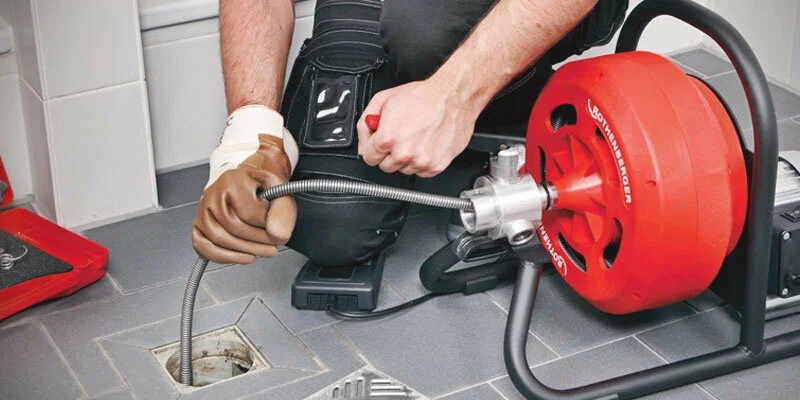 Plumber using a drain-cleaning machine in Johnstown