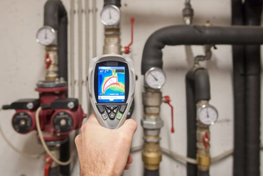 Plumber using a thermal imaging camera to inspect pipes in Johnstown