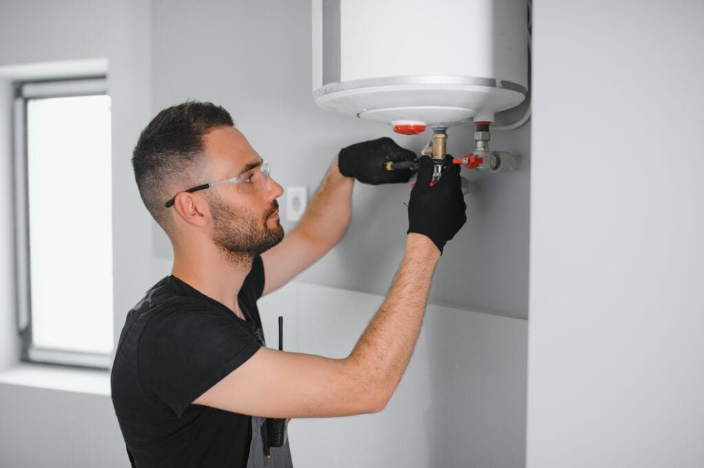 Technician performing water heater maintenance in Johnstown