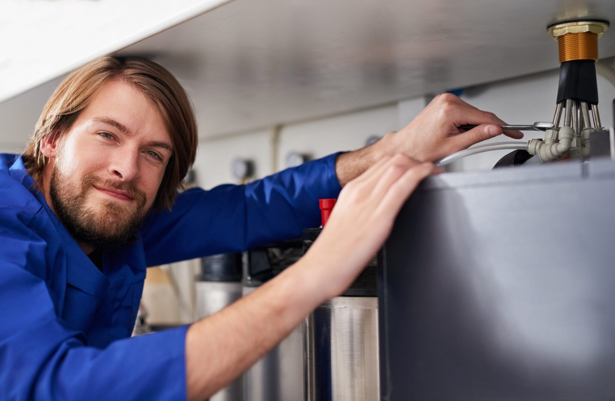 Technician servicing a residential water heater tank in Johnstown