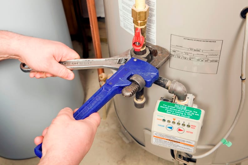 Plumber repairing a water heater valve in Johnstown